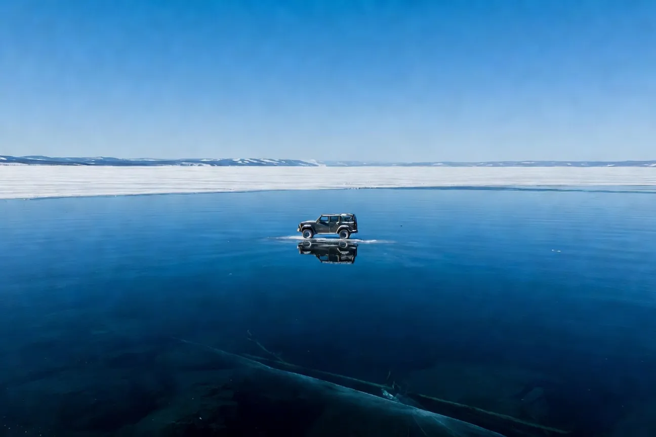 Traversée du Baïkal gelé en hiver, voiture sur glace transparente, ciel bleu