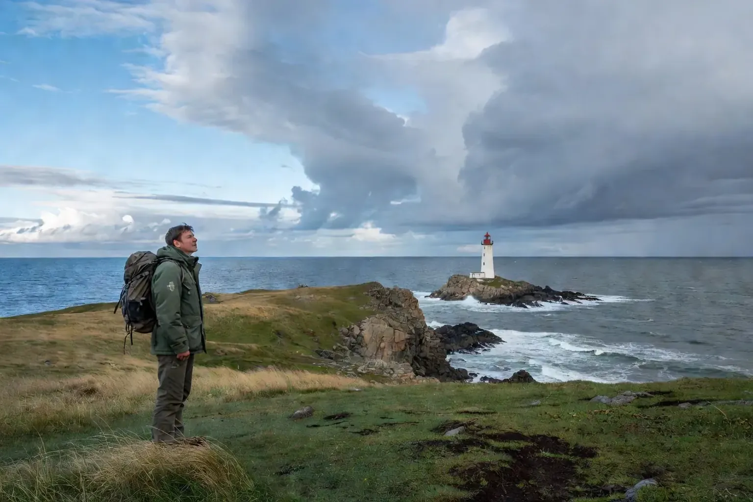 Sakhaline et îles Kouriles : randonneur face au phare d'Aniva sur la côte sauvage de la mer d'Okhotsk